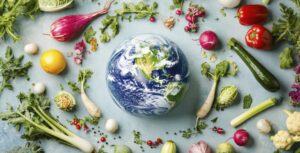 Globus in der Mitte, umgeben von frischem Gemüse wie Radieschen, Zucchini, Paprika und Kräutern – Symbol für nachhaltige Ernährung und den Einfluss unserer Lebensmittelwahl auf die Umwelt